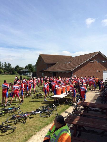 A group of cyclists taking a break and getting some refreshments.