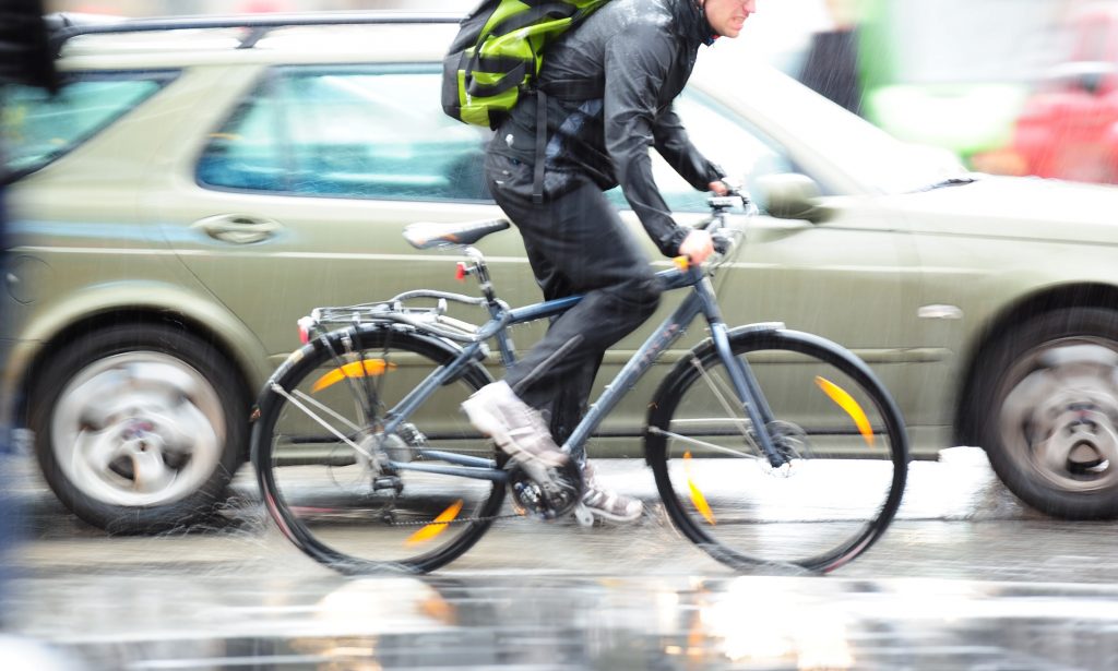 A cyclist in a rainy city.