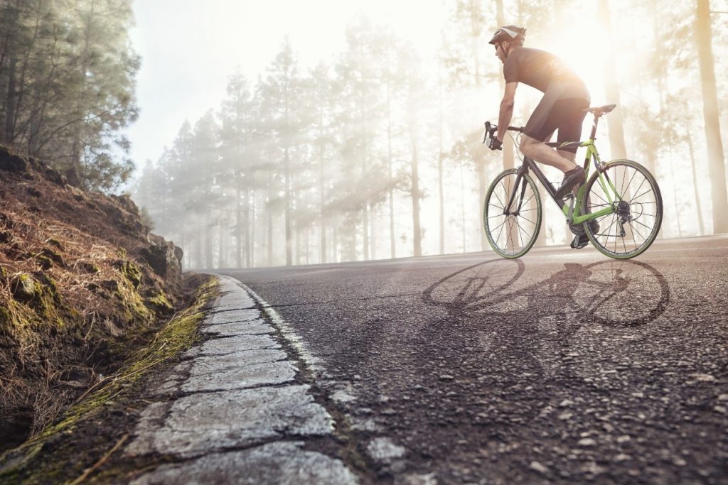 A cyclist on a misty road.