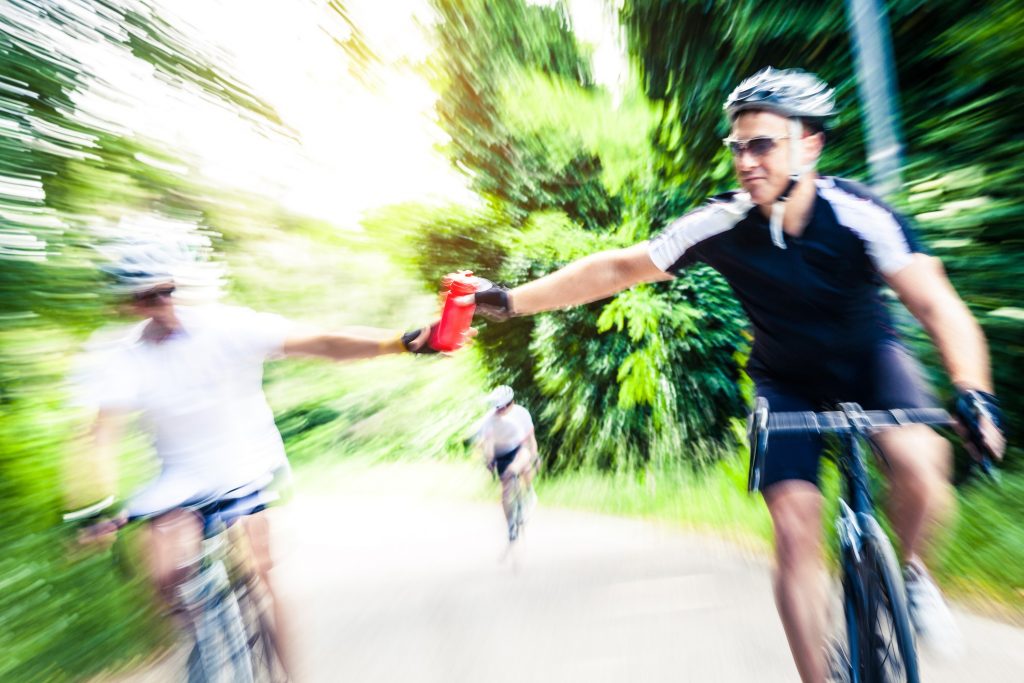 A cyclist getting a drink.