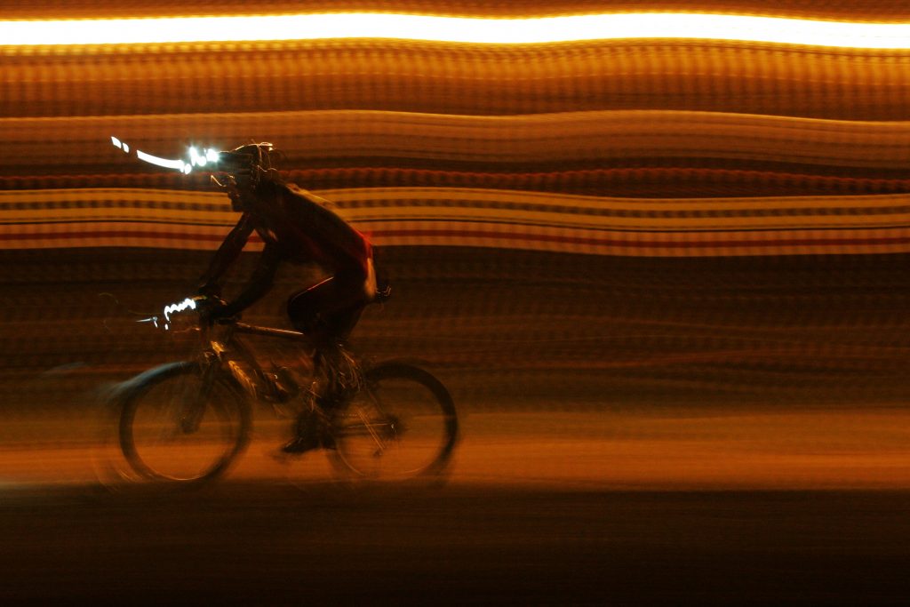 A cyclist with a head lamp on.