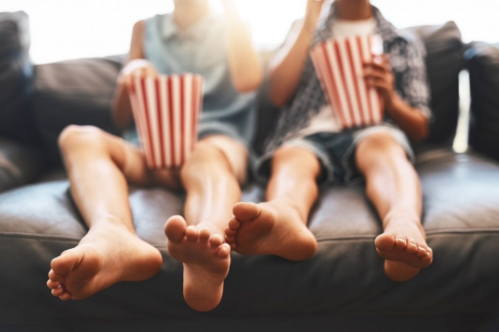 Two people watching a movie with popcorn.