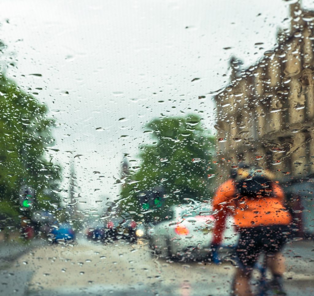 Street traffic through a rainy windscreen.