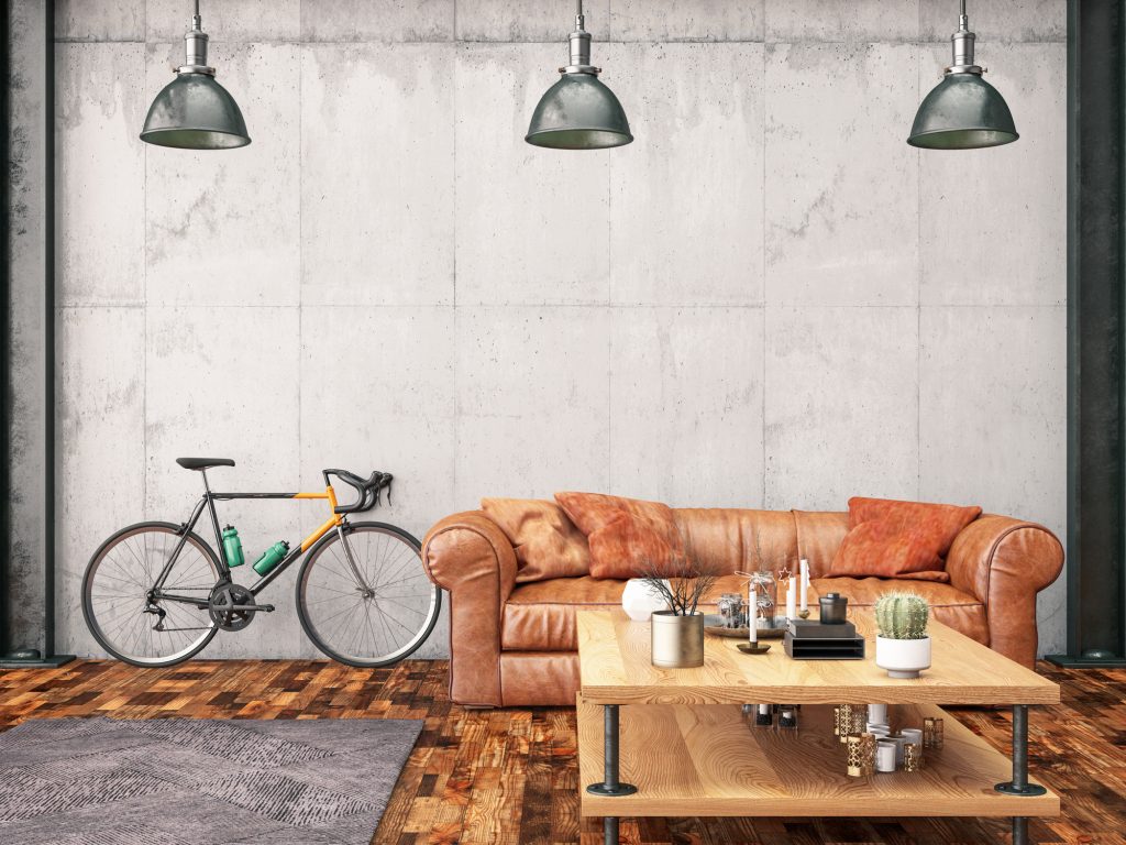 A bicycle indoors with a leather sofa.