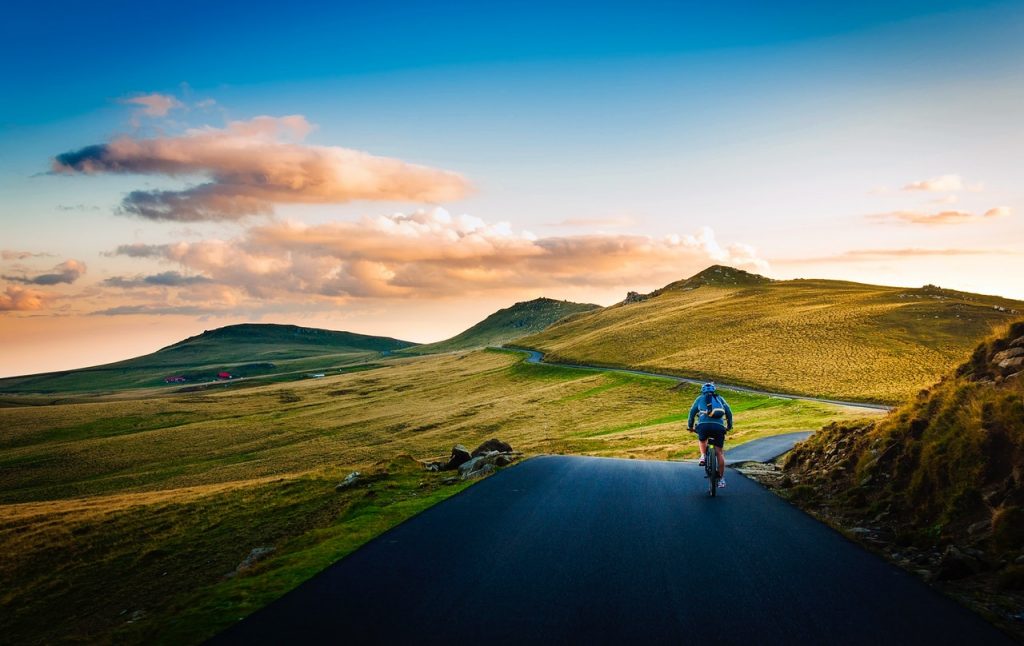 Rear view of a man cycling in the country.