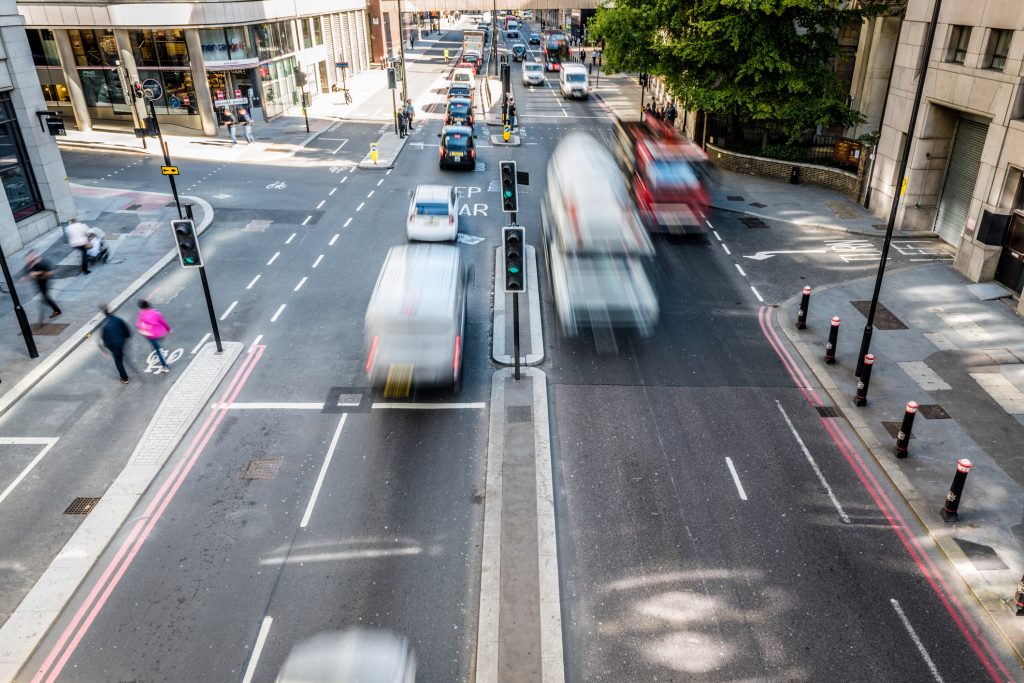 High angle view of blurred vehicles and people on a busy city street, London.