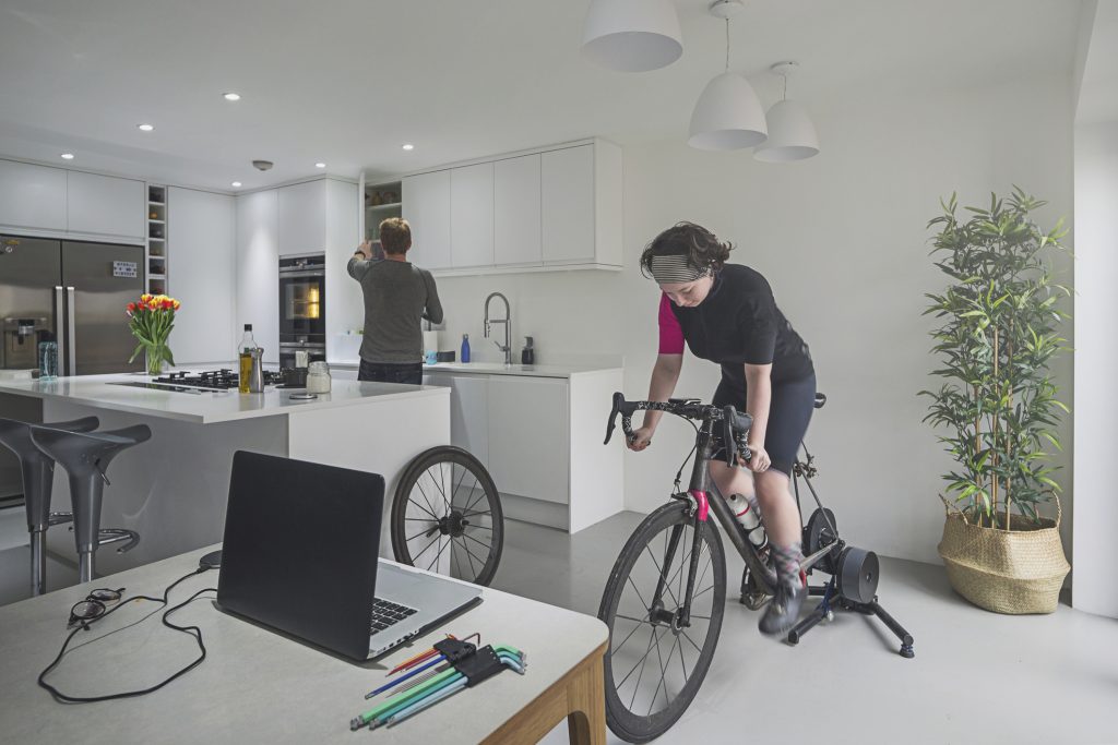 Teenage girl training on bike indoors.