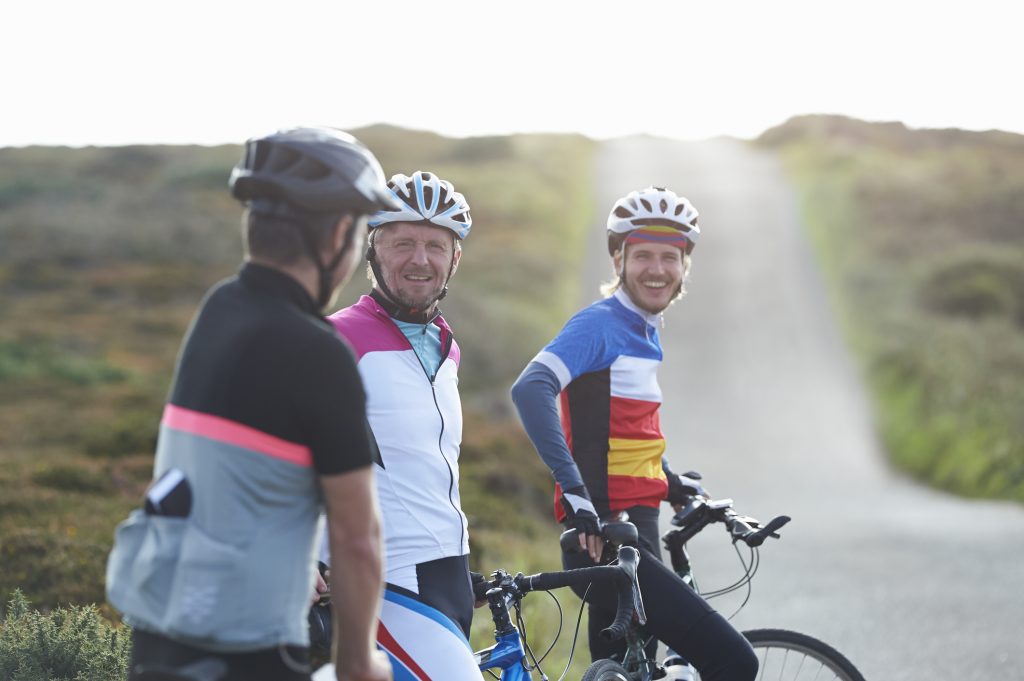Cycling group chatting on road in countryside.
