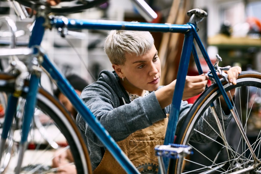 a woman repairing a bicycle brake