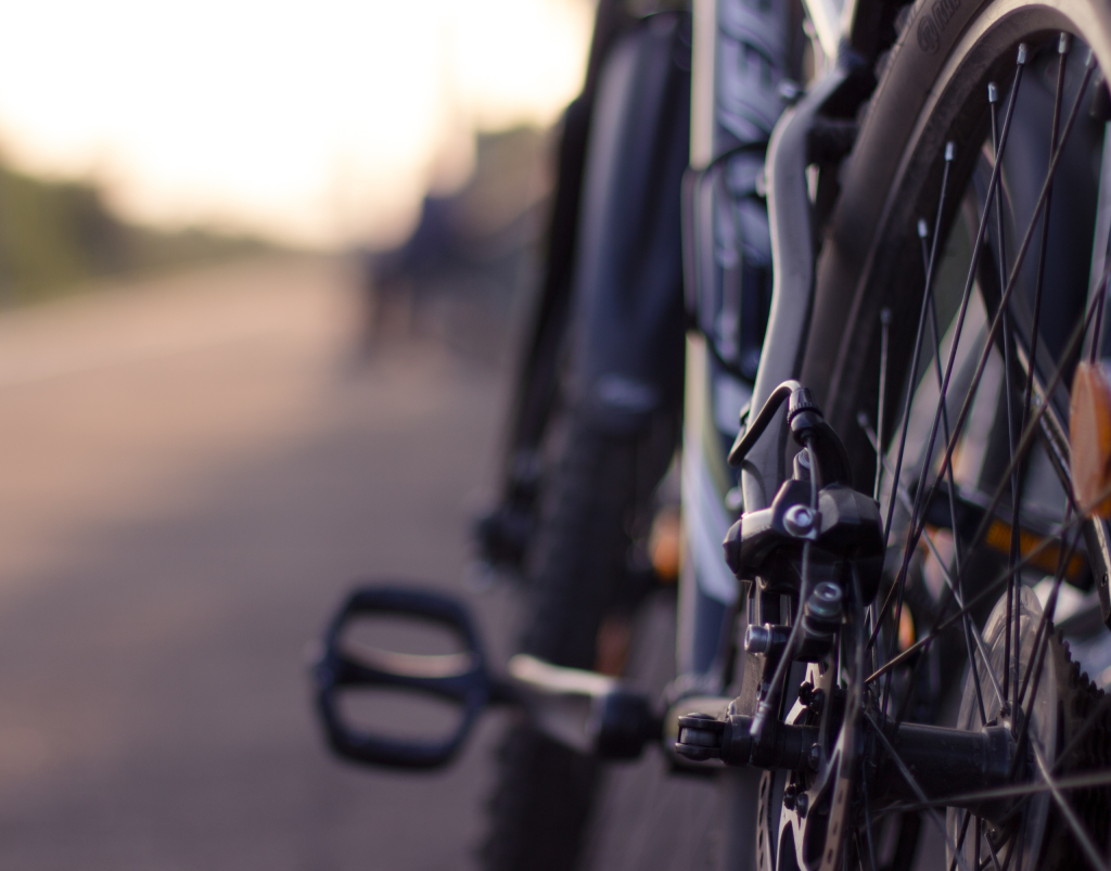 Close up image of a bicycle with a blurred road in the background.